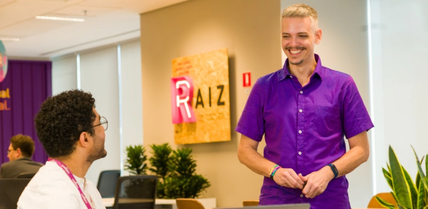 Funcionários sorrindo em um escritório da Raízen